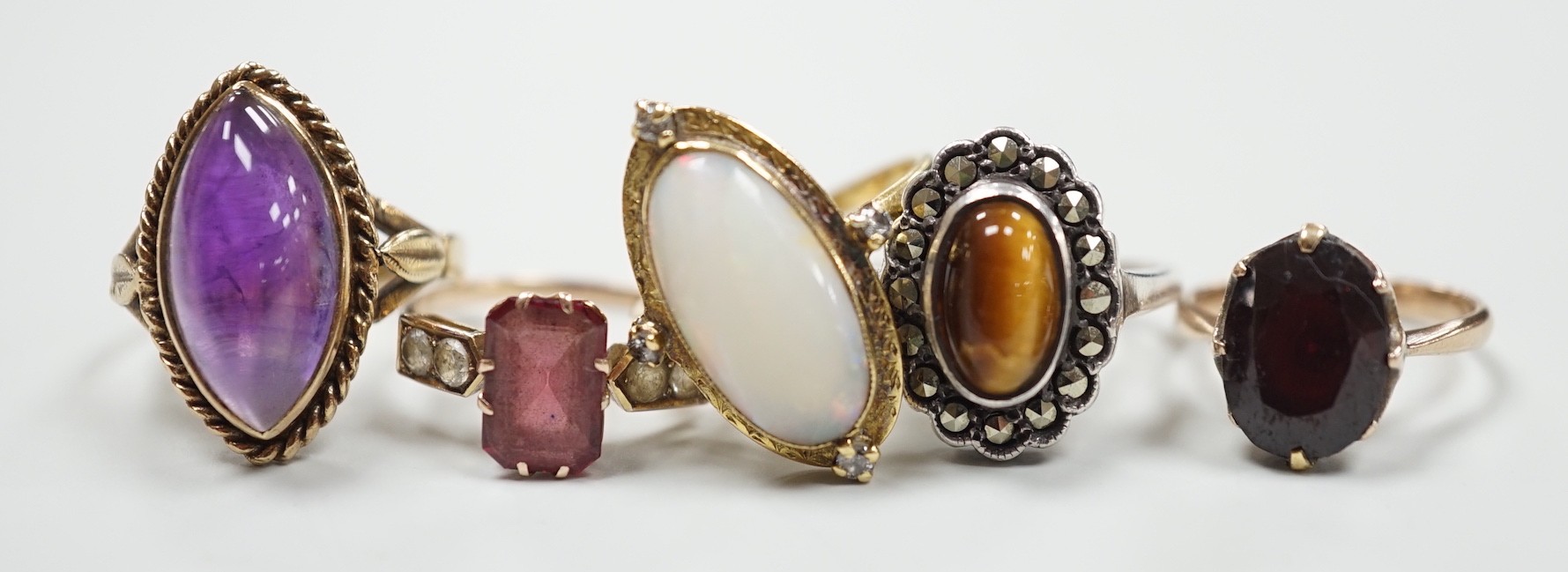 An 18ct, white opal and diamond chip set oval dress ring, size M, gross 4.8 grams and three other assorted 9ct gold and gem set dress rings, gross 10.3 grams and a white metal ring.